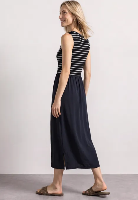 Midi-jurk met verschillende texturen en knoopdetails darkest blue Vrouw in een mouwloos gestreept topje, losse zwarte culotte-broek en bruine sandalen, zijwaarts pose.