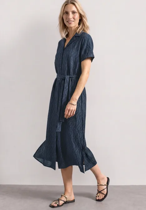 Midi-jurk met bowlingkraag darkest blue Vrouw in blauwe midi-jurk met ceintuur en zwarte sandalen.