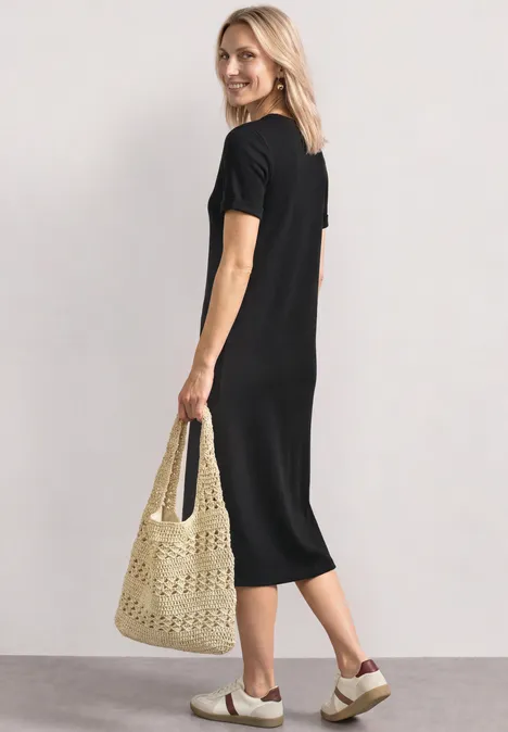 Midijurk met ribbelpatroon en ronde hals Black Vrouw in zwarte midijurk met gehaakte tas en plateauzandalen.