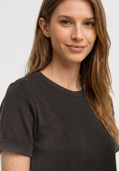 Midijurk met ribbelpatroon en ronde hals black coffee Vrouw in zwart T-shirt, zicht op bovenlichaam en schouders.