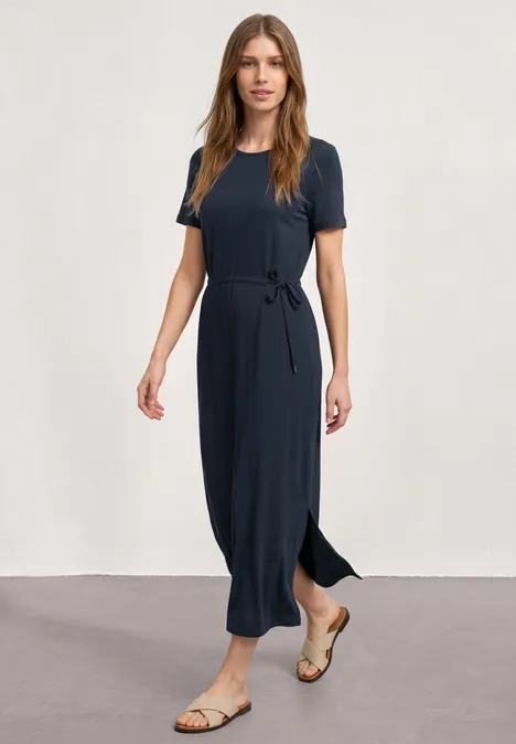 Midijurk van jersey met ronde hals darkest blue Vrouw in donkerblauwe midi-jurk met ceintuur en sandalen voor een neutrale achtergrond.