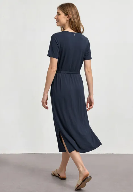 Midijurk van jersey met ronde hals darkest blue Vrouw van achteren in een marineblauwe midi jurk met korte mouwen, tailleceintuur, zijsplit en sandalen.