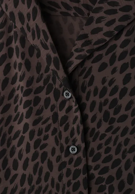 Midi-jurk met bowlingkraag en print molten earth Close-up van een bruin overhemd met zwart patroon en zwarte knopen.