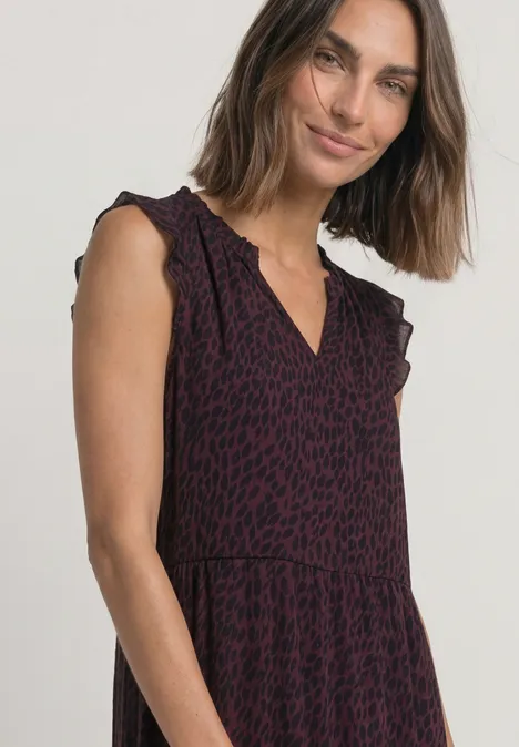 Maxi-chiffonjurk met volants en print rustic rouge Vrouw met halflang haar draagt een mouwloze jurk met paars-zwarte luipaardprint en V-hals.