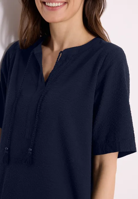 Knielange jurk in seersucker kwaliteit universal blue Vrouw draagt donkerblauwe top met korte mouwen, V-hals en koordtassels.