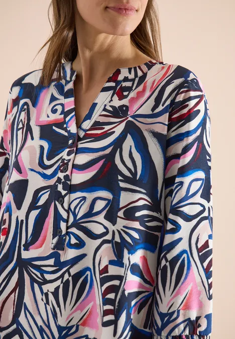 Knielange jurk met grafisch patroon universal blue Vrouw draagt hemd met abstracte bloemenprint in blauw, roze en wit.