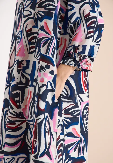 Knielange jurk met grafisch patroon universal blue Damesmantel met kleurrijk abstract dessin in blauw, roze en wit, zijzak.