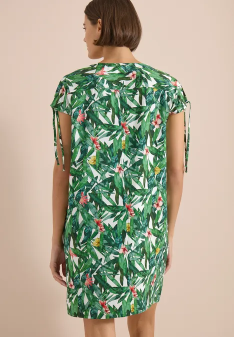 Knielange jurk met bloemenpatroon khaki Vrouw van achteren in een korte jurk met groen tropisch bladprint en zijstrikjes.