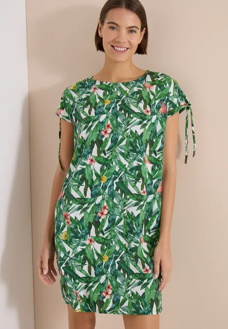 Knielange jurk met bloemenpatroon khaki Vrouw draagt een groen, kort mouw jurkje met tropische bladprint.