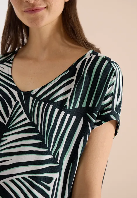 Knielange jurk met ronde V-hals universal blue Vrouw in shirt met abstract patroon van zwart-wit-groene strepen.