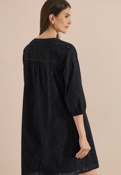 Knielange jurk met 3/4-mouwen en borduursel Black Vrouw van achteren in een zwarte tuniek met broderie anglaise en driekwartmouwen.