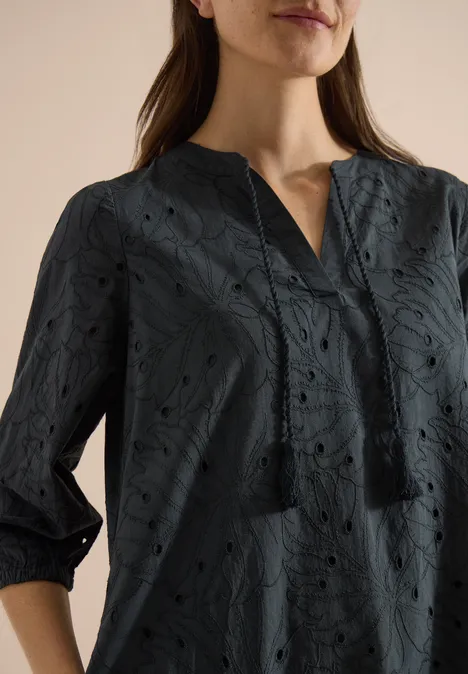 Knielange jurk met 3/4-mouwen en borduursel palm breeze green Een vrouw draagt een donkerblauwe blouse met bloemenknipwerk, driekwartmouwen en V-hals.