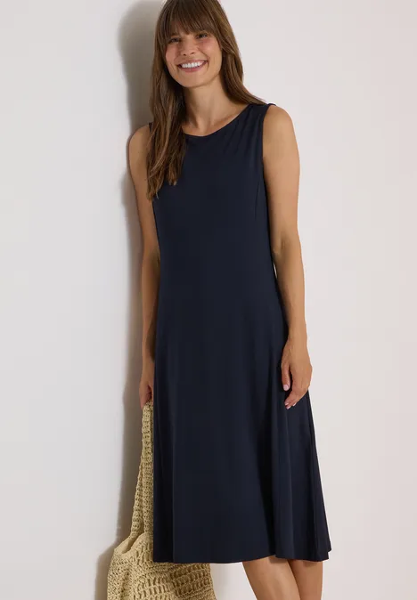 Midi-jurk met ronde hals van jersey urban dark blue Vrouw in mouwloze donkerblauwe midi-jurk met nettas, glimlachend.