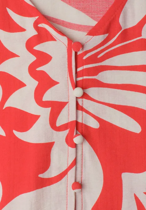 Midi-jurk met V-hals en print chili red Close-up van rood-witte stof met abstract bloemmotief en bijpassende knopen.