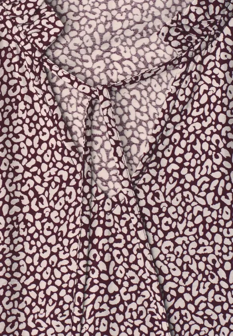 Knie-lange jurk met V-hals en print vanilla sand Bruin-beige stof met luipaardprint, in het midden van het beeld geknoopt.