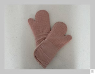 Overhead view of Food 52 silicone oven mitts overlapping on a white surface