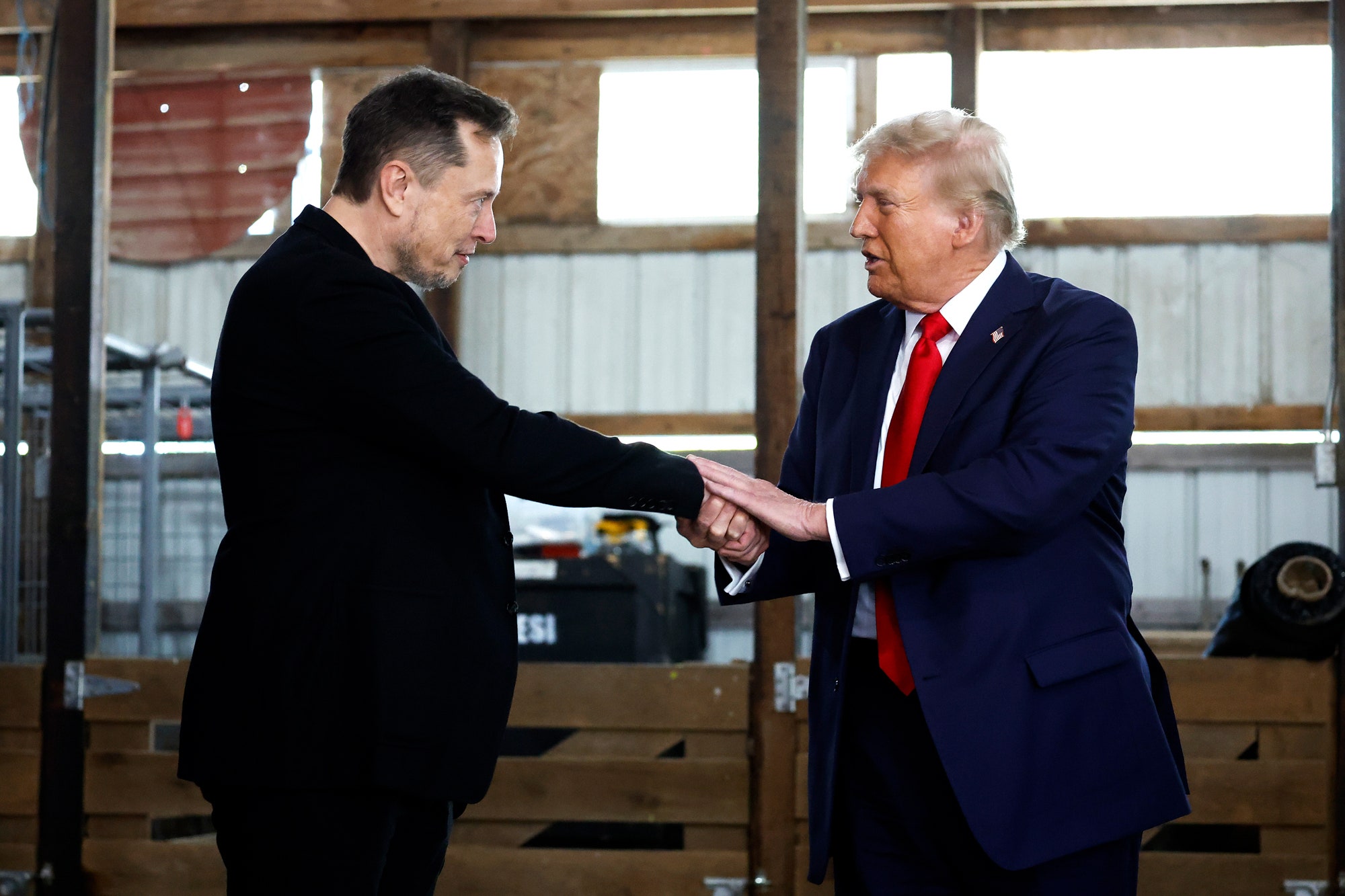 Elon Musk  shakes hands with Donald Trump back stage during a campaign rally at the Butler Farm Show grounds on October...