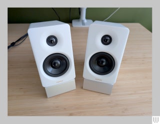 Edifier M60 small white rectangular speakers on top of a wooden desk