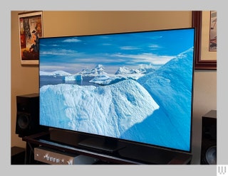 Front view of the Samsung QN90D QLED TV with the screen showing a scene of icebergs in the ocean on a sunny blue sky day