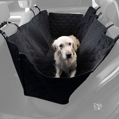Fekete autóülés-védő takaró steppelt dizájnnal, fejtámlákhoz rögzítve. Golden Retriever ül rajta az autóban.