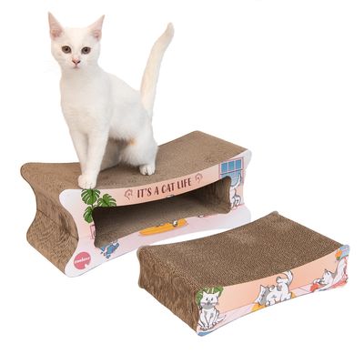 Cardboard scratching furniture with 'It's a cat life' inscription, two pieces, decorated with cat motifs. White cat stands on the top part.