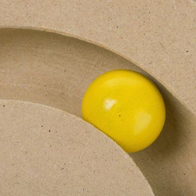 Yellow wooden ball in a curved MDF wood track, part of an interactive pet toy.