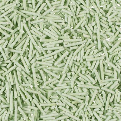 Close-up of green, elongated pellets, possibly cat litter or bedding.