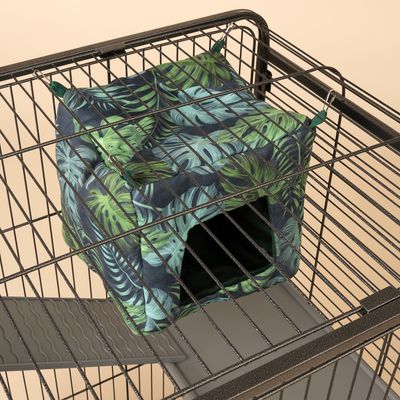 Hamaca con estampado de hojas tropicales, fijada a jaula metálica. Entrada visible, adecuada para animales pequeños.