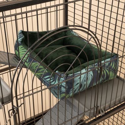Cojín verde acolchado con estampado de hojas tropicales en una jaula metálica. Adecuado para usar en jaulas para animales.