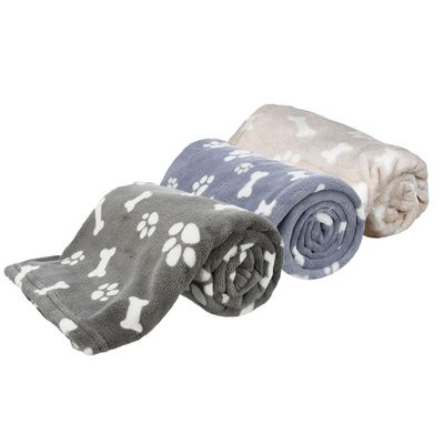 Drei zusammengerollte Decken in Grau, Blau und Beige mit weissen Pfoten- und Knochenmustern.