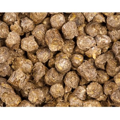 Close-up of compressed brown feed pellets with visible plant fibres and grains, showing texture and ingredients for assessing product quality.