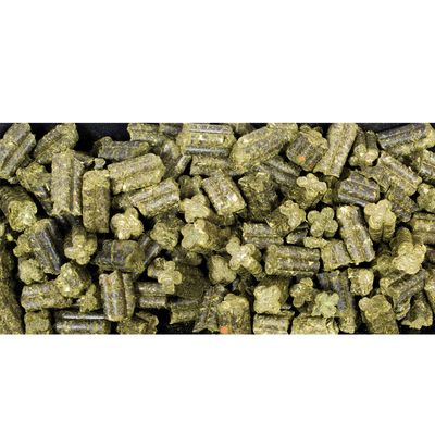 Zöld, préselt pellet és csillag alakú darabok növényi anyagból, a táp közeli képe.