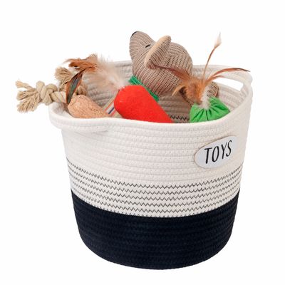 Cesta de tela con la inscripción 'Toys', llena de juguetes para mascotas como cuerda, zanahoria y ratón.