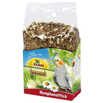 JR Farm Individual Nymphensittich, eleségkeverék kamillával és édesköménnyel, frissen a gazdaságból. A csomagoláson egy nimfapapagáj zöld háttér előtt látható.