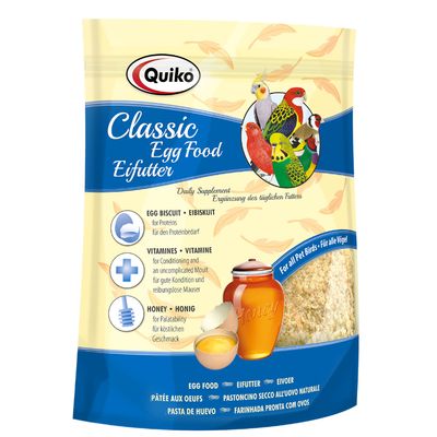 Quiko Classic egg food suplemento diario para aves, 500 g. Texto visible: Essential Amino Acids, Protein & Calcium, Key Vitamins. Imagen de mezcla granulada y pájaros en el envase.
