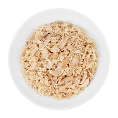 Primer plano de carne de pollo picada en un cuenco blanco, apta como alimento para animales.
