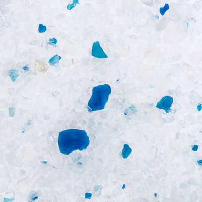 Close-up of white cat litter with blue granules.