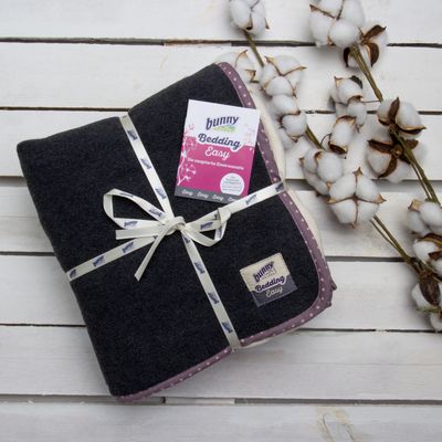 Bunny Bedding Easy bedding mat, highly absorbent, dark grey with purple edge, decoratively packed with ribbon and label. Cotton branches in background.