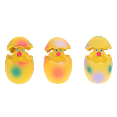 Tres juguetes amarillos en forma de pollitos saliendo de coloridas cáscaras de huevo. Diseño colorido con detalles rojos, verdes y azules.