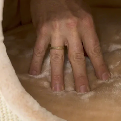 Hand pressing soft beige material to demonstrate the product's padding and comfort. Hand pressing soft beige material to demonstrate the product's padding and comfort.
