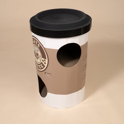 Katzenhöhle in Form eines braunen Kaffeebechers mit schwarzem Deckel, mehreren Eingängen und integriertem Kratzkarton. Aufdruck: 'Cats Coffee'.