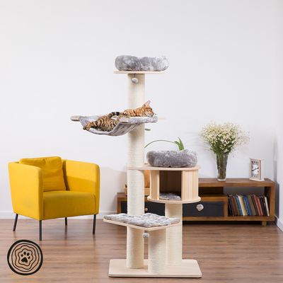 Cat tree with multiple levels, sisal posts and grey resting areas. Bengal cat resting on a hammock. Modern living room in the background.