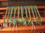 front-of-warp-cut-and-tied-onto-front-apron-bar Front ends of the warp are cut and tied onto the front apron bar.