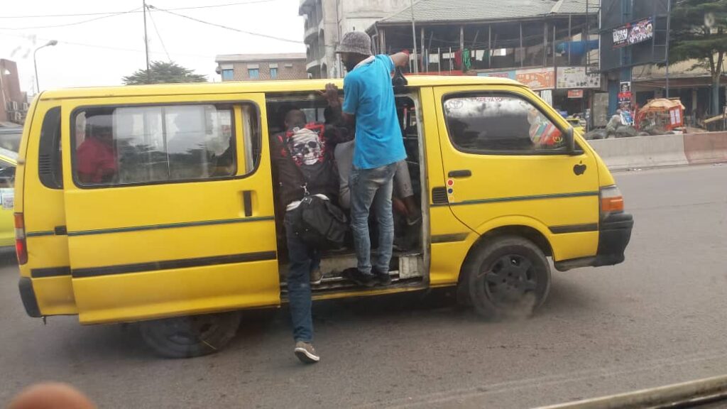 Article : À kinshasa, les bus des transports en commun n’ont ni klaxon ni rétroviseurs : un collaborateur du chauffeur se charge de les remplacer