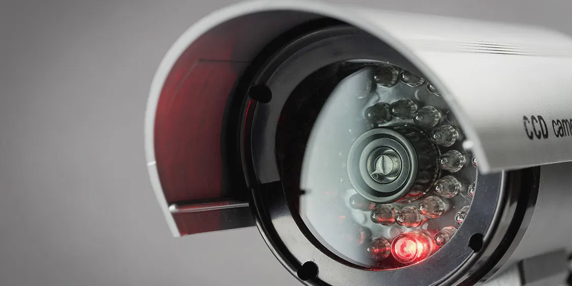 Close-up of a security camera lens with infrared sensors, symbolizing IT security maintenance services by Piccola Tech Support.