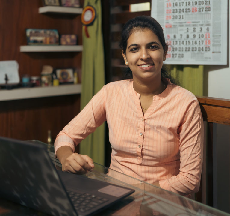 A woman sitting at a dining table working on her laptop