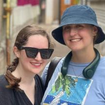 divas jaunas sievietes stāv viena otrai blakus