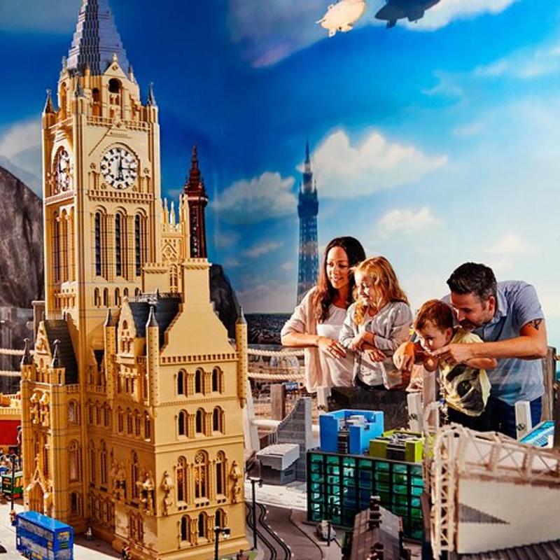en familj som leker med en legomodell av ett klocktorn