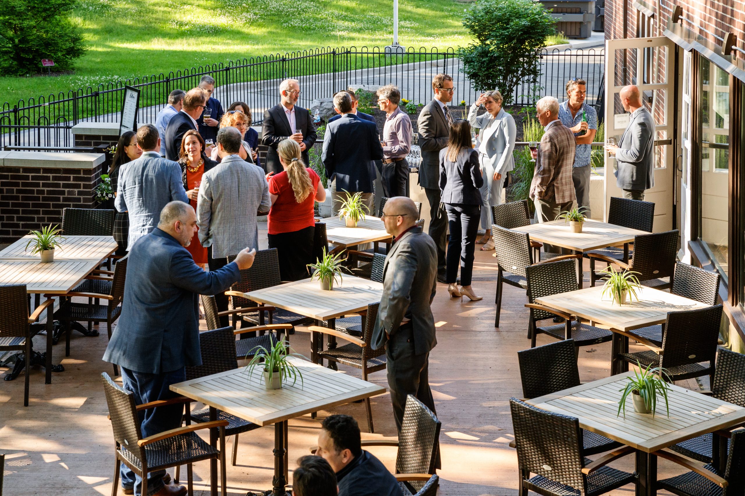 A group of people talking on an outdoor patio.