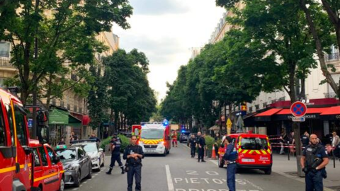 Des policiers français se tiennent à côté de véhicules de secours, près du café Le Ramus, à Paris, le 17 juillet 2024